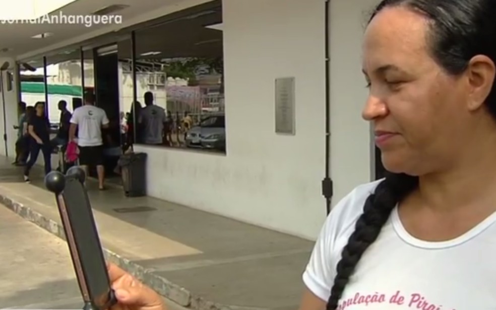 Tia que acompanha siamesas em hospital de Goiânia conversa com irmã, que está na Bahia, por telefone — Foto: Reprodução/TV Anhanguera