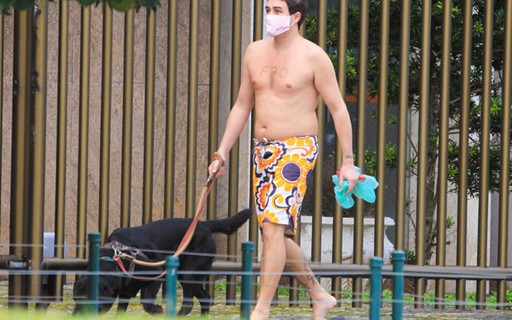 Felipe Dylon passeia sem camisa e de máscara com cachorro em Ipanema