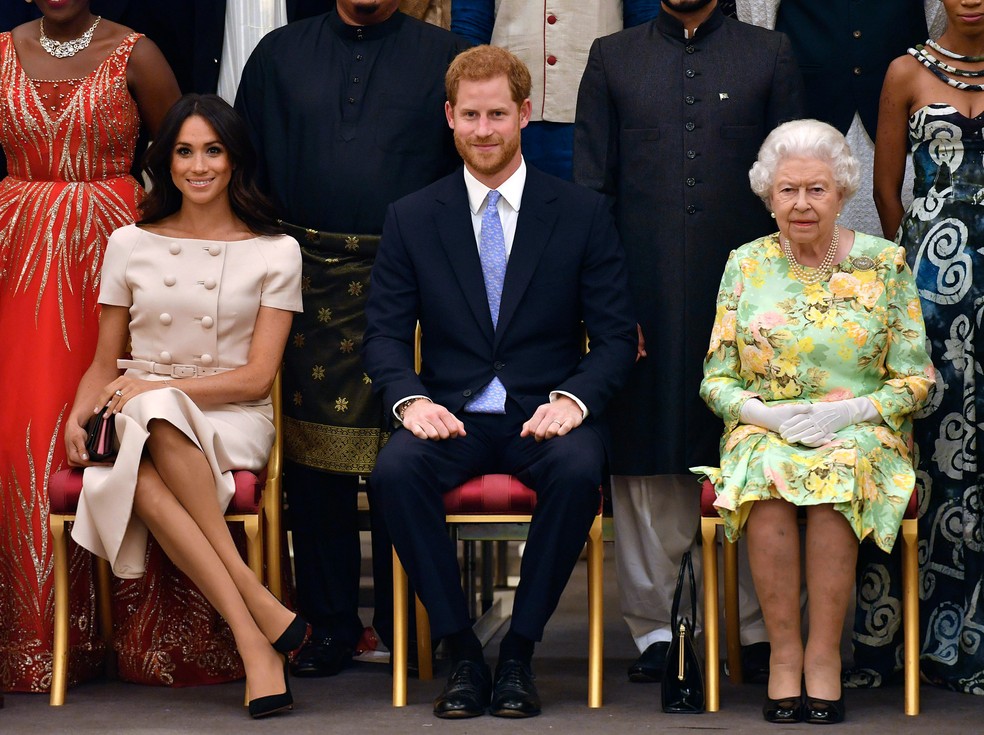 Foto de arquivo de 2018 mostra a rainha Elizabeth, o príncipe Harry e Meghan, duquesa de Sussex, posam para fotos durante uma cerimônia no Palácio de Buckingham, em Londres — Foto: John Stillwell/AP/Arquivo