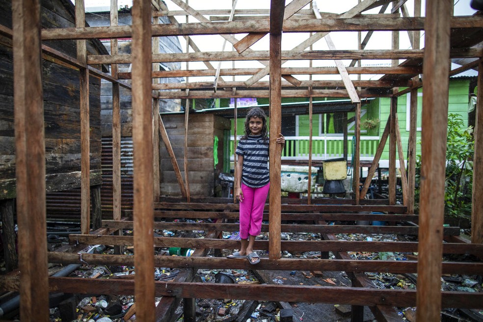 Menina se equilibra em construção parcialmente destruída após passagem do furacão Julia em Bluefields, na Nicarágua, antes de o fenômeno se enfraquecer e se tornar tempestade tropical, em 9 de outubro de 2022. — Foto: Inti Ocon/ AP 