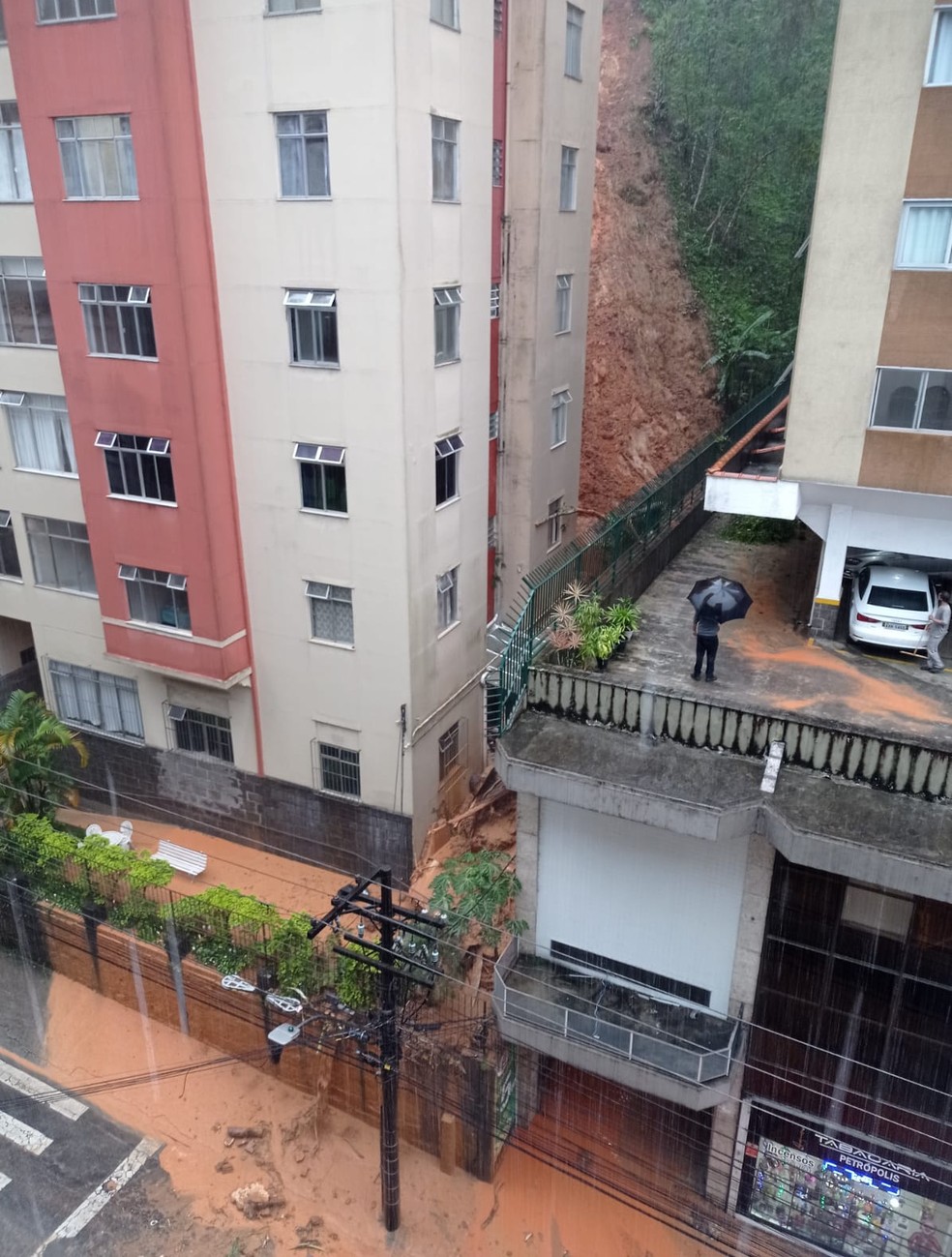 Barreira desliza atrás de prédio em Petrópolis, RJ, após chuvarada na tarde desta terça-feira (15) — Foto: Reprodução/Redes sociais