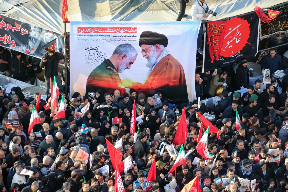 Cartaz com a foto do líder espiritual do Irã, aiatolá Ali Khamenei, concedendo a maior honra militar do país ao general Qasem Soleimani, morto em ataque americano, é visto durante funeral em Teerã, nesta segunda-feira (6) — Foto: Atta Kenare / AFP