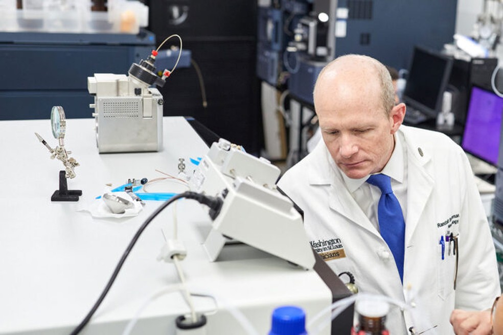 O neurologista Randall Bateman inspeciona um espectrômetro de massa, aparelho capaz de identificar moléculas  — Foto: Divulgação: Matt Miller