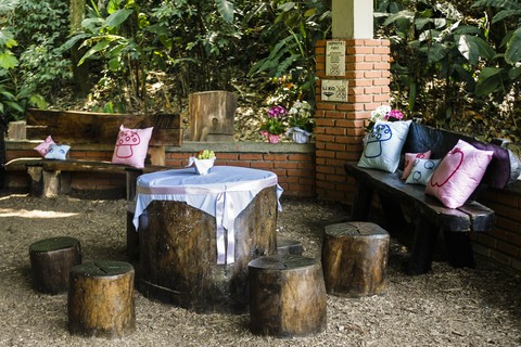 Em uma área coberta, os convidados podiam se sentar em bancos de madeira. Os detalhes seguem os tons da festa: azul e rosa.