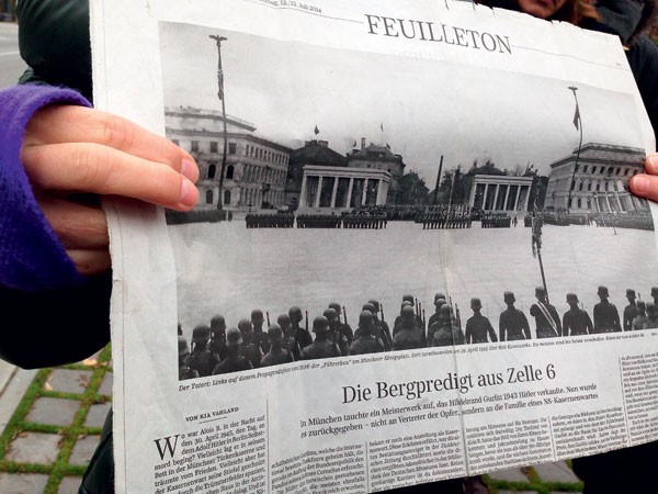 Muitas memórias: A guia da excursão, Tina Olschlager, mostra um jornal antigo com foto de praça onde o exército de Adolf Hitler fazia demonstrações de poder. O passeio a pé que conta a história do nazismo na cidade é o mais procurado entre os turistas (Foto: Magrit Behrens, Zentralinstitut Kunstgeschichte)