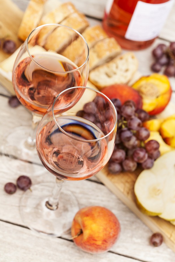 Two glasses of rose wine and board with fruits, bread and cheese on wooden table, shallow DOFTwo glasses of rose wine and board with fruits, bread and cheese on wooden table Two glasses of rose wine and board with fruits, bread and cheese on wooden table  (Foto: Getty Images/iStockphoto)