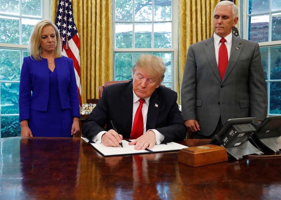 O presidente dos EUA, Donald Trump, assina uma ordem executiva sobre a política de imigração, na Casa Branca, em Washington (Foto: Leah Millis/Reuters)