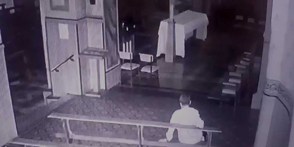 Antes do furto, suspeito ficou um tempo sentado no banco da igreja no centro de Botucatu (SP). — Foto: Câmera de segurança/ Reprodução 