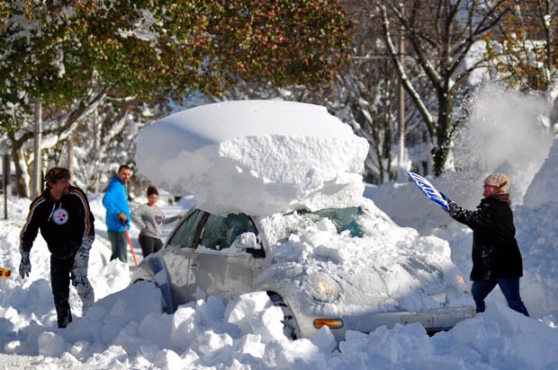 Moradores usam pás para retirar neve que encobriu carros em Buffalo após nevasca histórica, no último dia 20 (Foto: Getty Images)