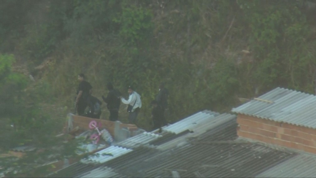 Bandidos tentam se esconder na mata da favela — Foto: Reprodução/TV Globo