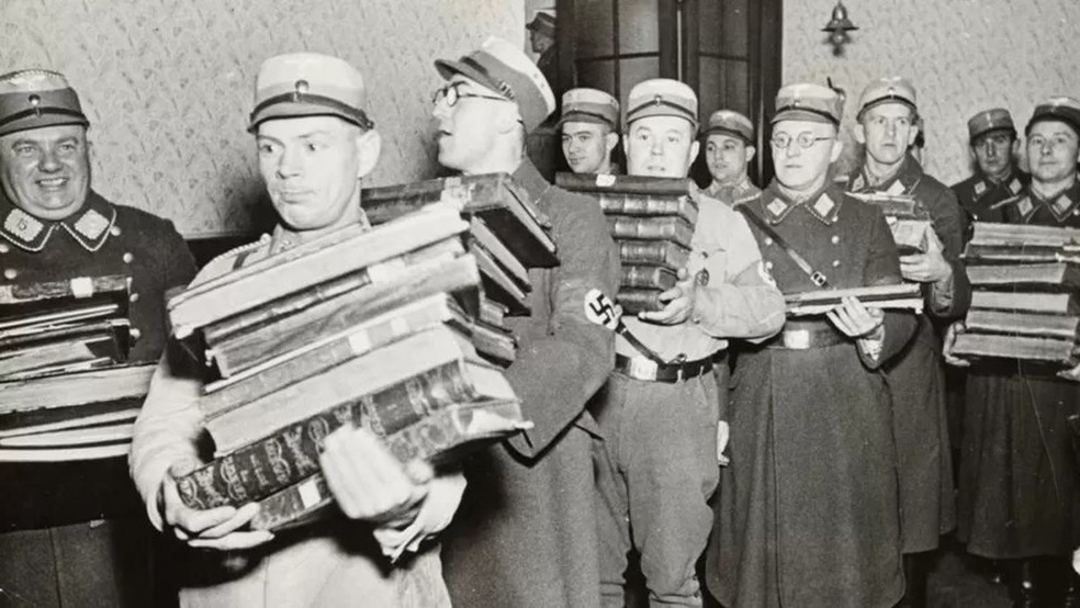 Oficiais nazistas carregando livros, supostamente para serem queimados — Foto: YAD VASHEM PHOTO ARCHIVE via BBC