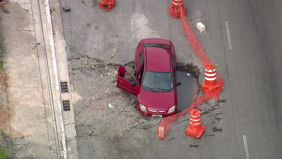 Carro cai em buraco na Avenida Itaquera — Foto: Reprodução/TV Globo