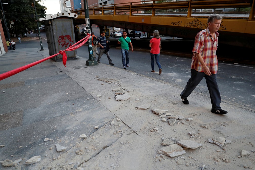 Pessoas andam perto de detritos em Caracas depois que um terremoto atingiu a costa norte da Venezuela (Foto: Reuters/Carlos Garcia Rawlins)