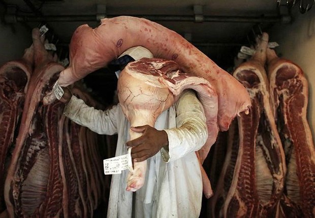 Funcionário carrega pedaços de carne em açougue de São Paulo (Foto: Nacho Doce/Reuters)