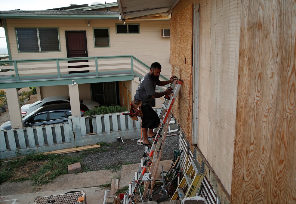 Morador protege janela com madeira em Kapolei, no HavaÃ­, na quarta-feira (22), na preparação para a chegada do furacão Lane  (Foto: John Locher/AP)