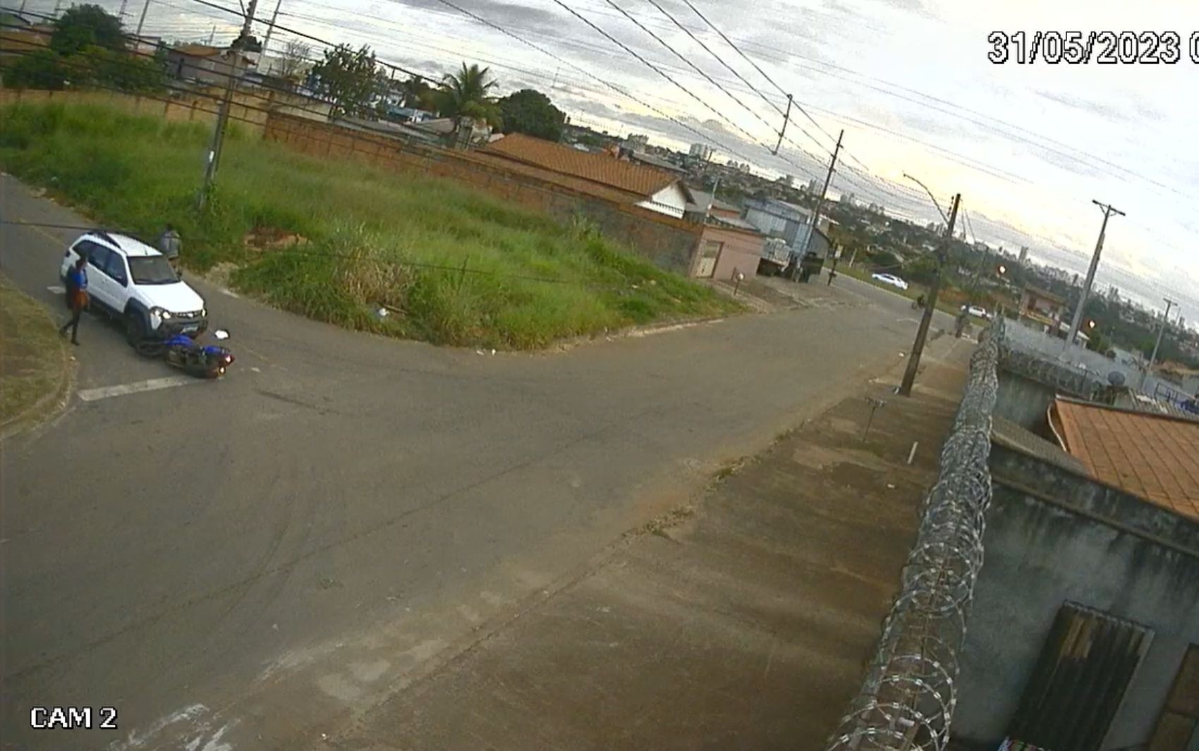 Motociclista escorrega em rua, é atropelado por carro e sai andando; vídeo