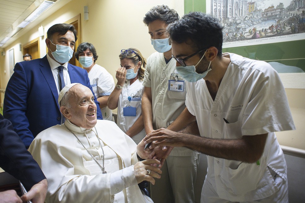Sentado em uma cadeira de rodas, Papa Francisco é saudado pela equipe da Policlínica Agostino Gemelli, em Roma, em 11 de julho de 2021, onde foi hospitalizado para uma cirurgia no cólon — Foto: Vaticano via AP