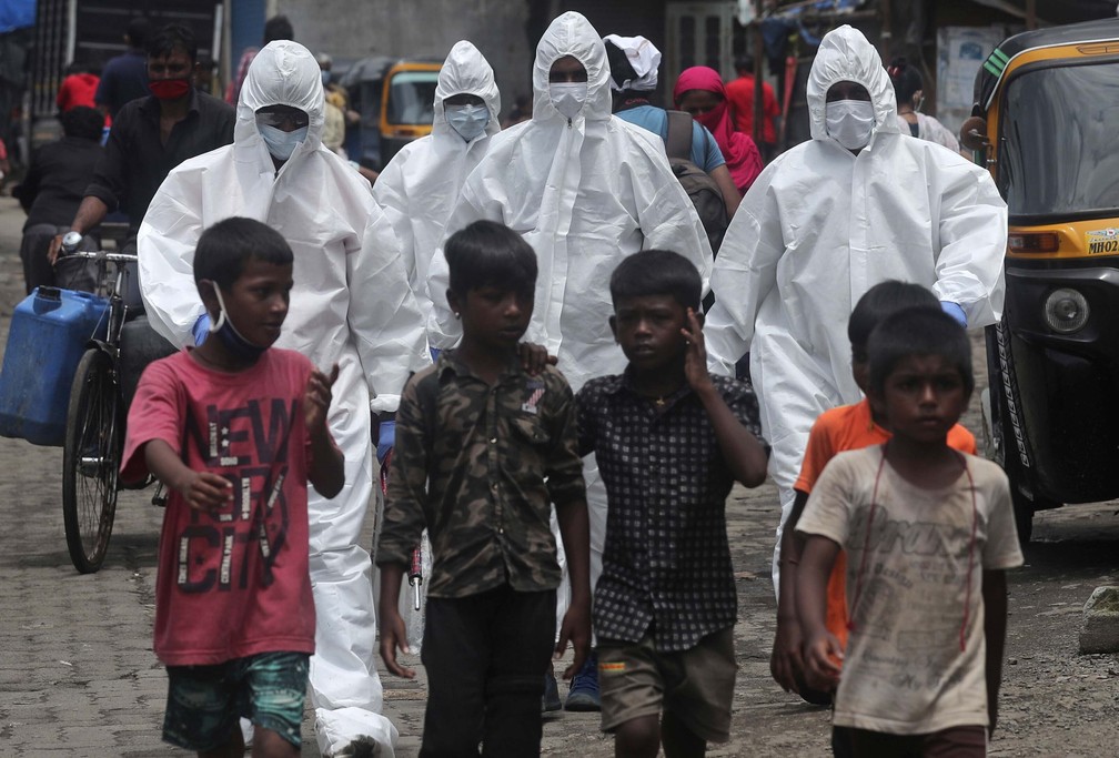 10 de julho - Profissionais da sa&uacute;de chegam para rastrear pessoas em busca de sintomas de Covid-19, em Mumbai, na &Iacute;ndia. A &Iacute;ndia ultrapassou a R&uacute;ssia e se tornou o terceiro pa&iacute;s mais afetado pela pandemia de coronav&iacute;rus &mdash; Foto: Rafiq Maqbool/AP