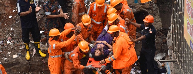 Equipes de resgate retiram sobrevivente dos escombros de um prédio que desmoronou, em Mumbai, na Índia  — Foto: IMTIYAZ SHAIKH / AFP