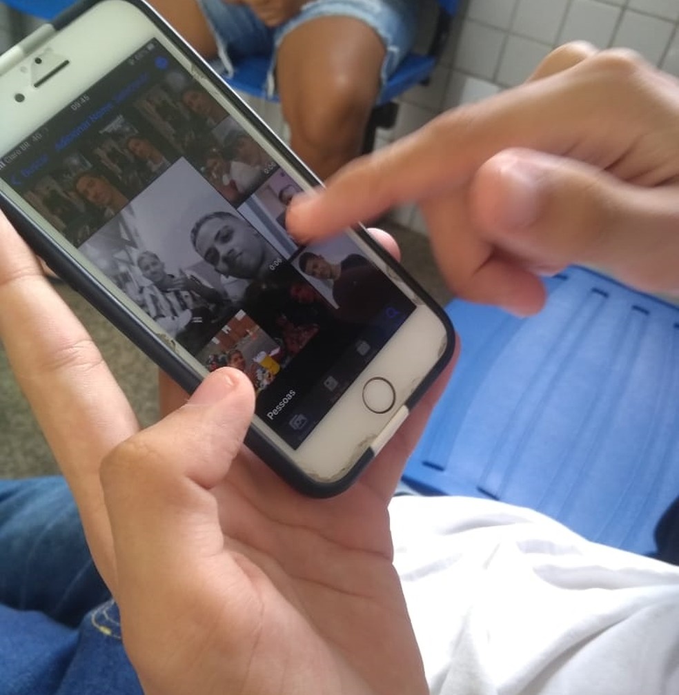 Amigo de Luian oliveira e Anael Colins olha imagem dos jovens pelo celular em Teresina — Foto: Caroline Oliveira/g1 PI