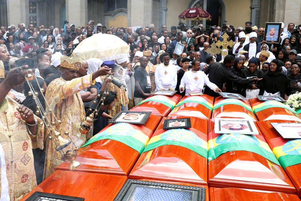 Religiosos abençoam os caixões com um incenso durante funeral simbólico das vítimas do desastre com avião da Ethiopian Airlines, na Igreja Ortodoxa da Santíssima Trindade, em Addis Abeba, na Etiópia, neste domingo (17)  — Foto: Tiksa Negeri/ Reuters