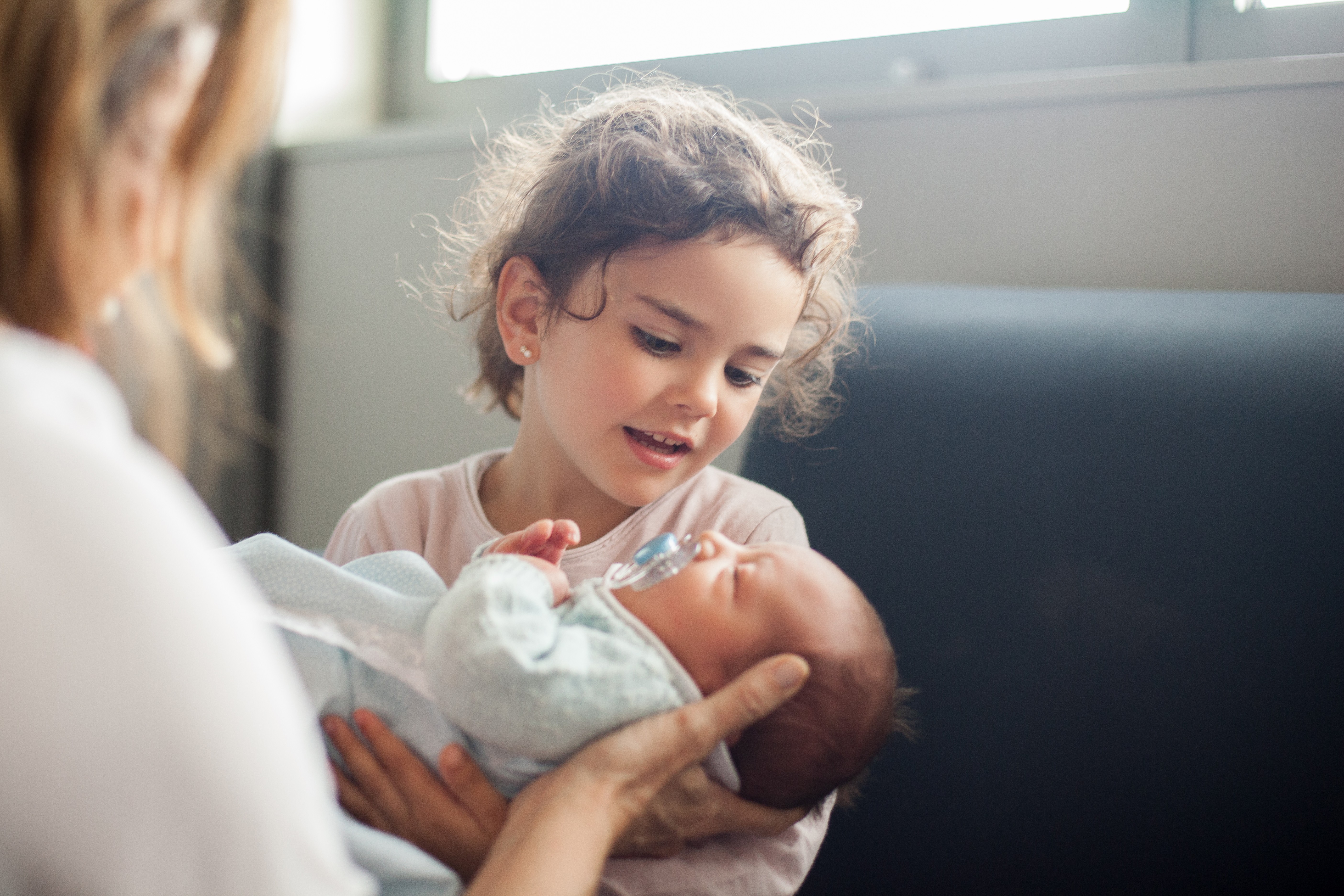 Criança olhando recém-nascido  (Foto: Getty Images)