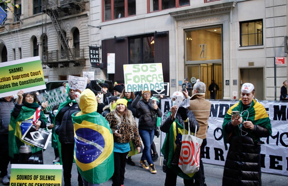 Manifestantes na porta de hotel de autoridades brasileiras exibem cartazes golpistas