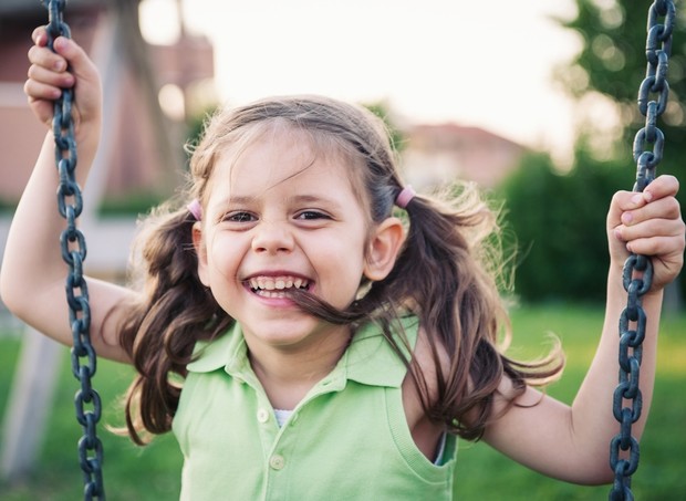 Criança brincando de balanço no parquinho (Foto: Shutterstock)