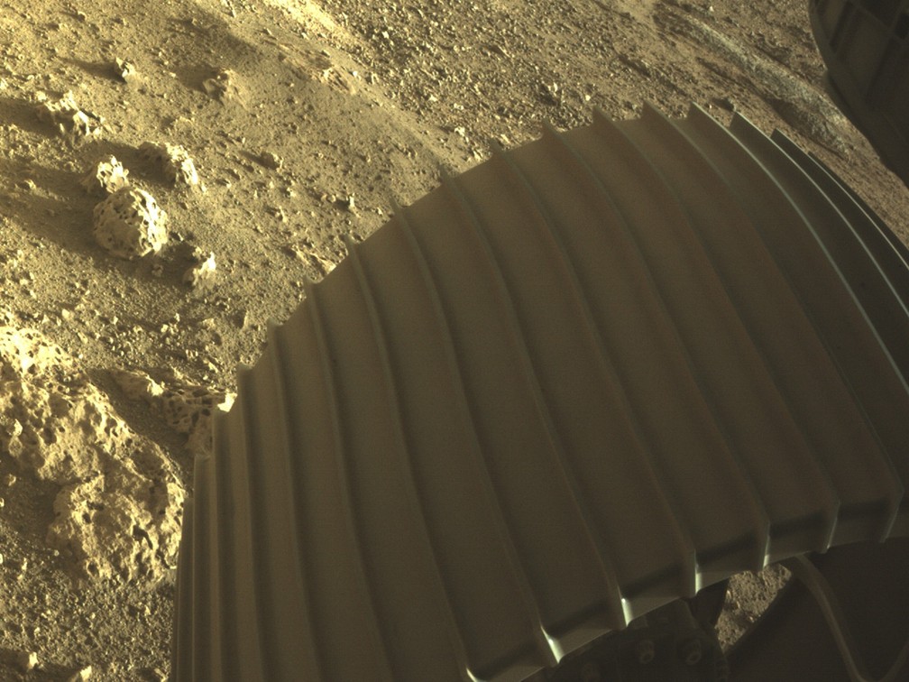 Uma das rodas do robô Perseverance, da Nasa, tocando o solo de Marte. — Foto: NASA