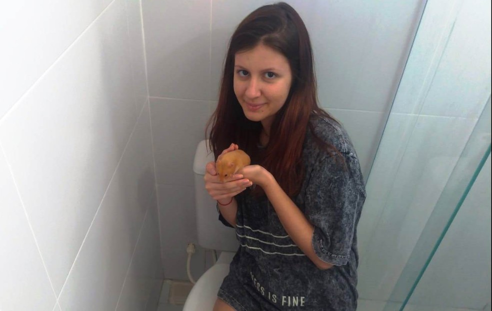 Isabelle Tafuri segurando o hamster que foi resgatado do cano; no lado esquerdo da foto &eacute; poss&iacute;vel ver o ralo de onde ele foi retirado &mdash; Foto: Isabelle Tafuri/Arquivo pessoal