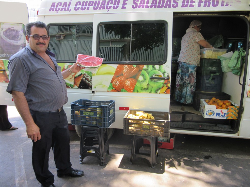 O empresário José Guedes segura fatia de melancia; ele vende até 70 fatias por dia durante a época de calor em Brasília (Foto: Raquel Morais/G1)