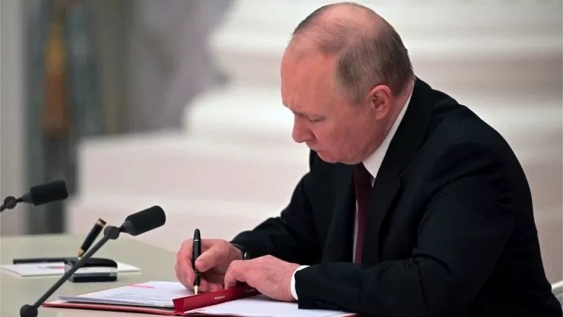 O presidente russo, Vladimir Putin, assina decreto reconhecendo duas regiões separatistas apoiadas pela Rússia no leste da Ucrânia como independentes (Foto: BBC via Reuters)