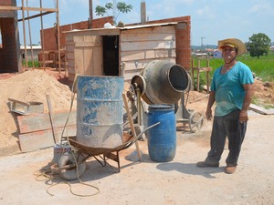 o servente de pedreiro Manoel Mota precisa ir buscar água em uma represa para a obra não parar.  (Foto: Pâmela Fernandes)