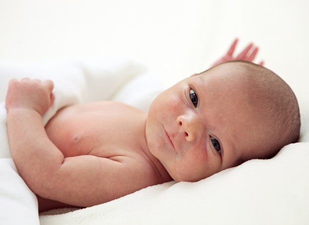 Bebê recém-nascido deitado na cama (Foto: Shutterstock)