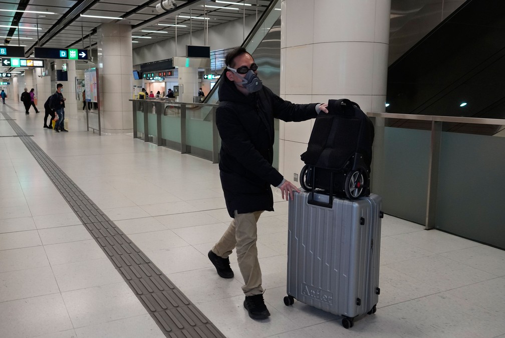 Passageiro usa máscara e óculos de natação ao chegar a uma estação de metrô em Hong Kong, nesta terça-feira (28)  — Foto: Vincent Yu/AP