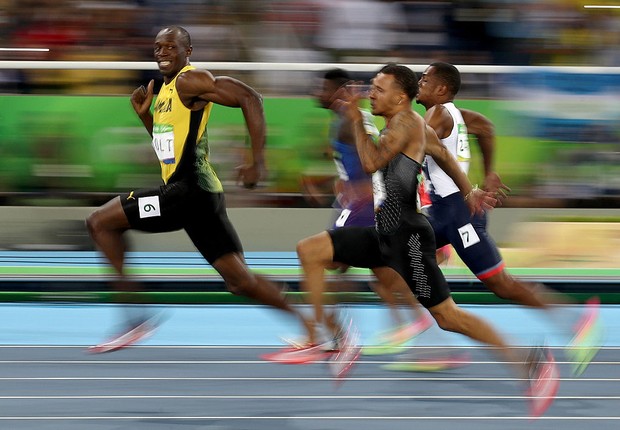 Usain Bolt sorri diante da vantagem em relação aos rivais (Foto: Cameron Spencer/Getty Images)