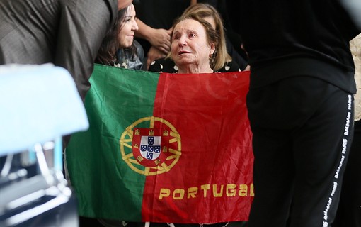 Maria do Céu Moraes segura bandeira de seu país natal, Portugal