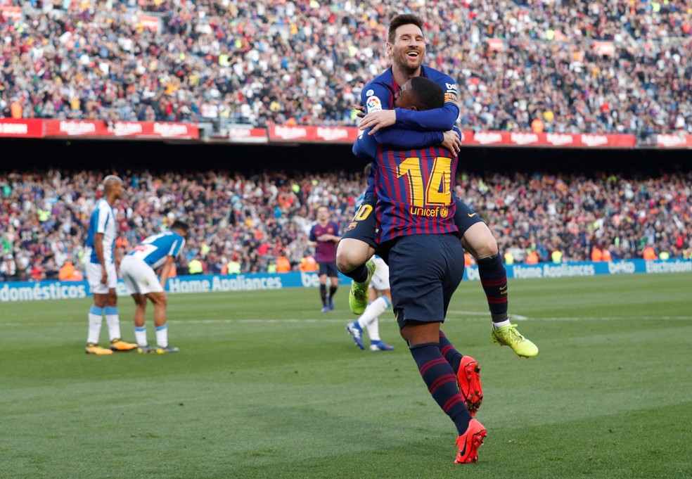 Messi abraça Malcom na comemoração do segundo gol do Barcelona sobre o Espanyol no sábado passado — Foto:  REUTERS/Albert Gea