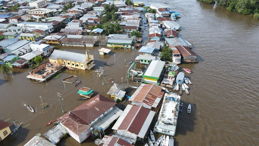 Cidade está 100% inundada pela cheia do Rio Solimões — Foto: Diego Peres/Secom e Arthur Castro/Secom