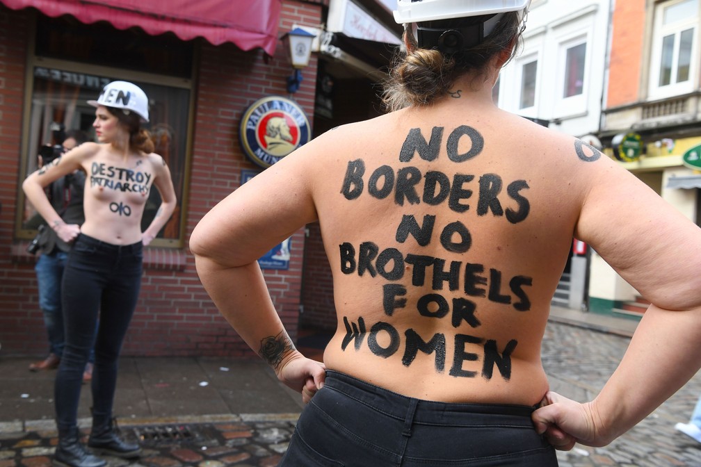 Integrantes do grupo feminista Femen fizeram protesto em rua em que se localizam casas de prostituição em Hamburgo, no norte da Alemanha, nesta sexta-feira (8). Manifestante escreveu nas costas “Sem fronteiras sem bordéis para mulheres”   — Foto: Patrik Stollarz / AFP