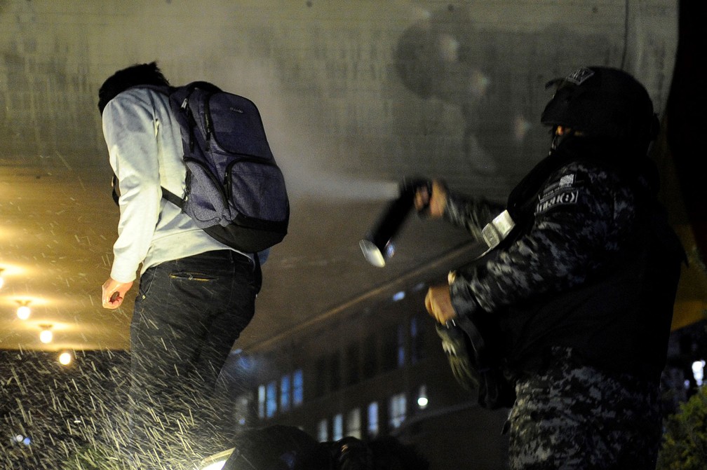 Policial joga spray de pimenta em apoiador do principal candidato presidencial da oposição a Evo Morales, Carlos Mesa, durante protesto em La Paz, na Bolívia — Foto:  Jorge Bernal / AFP