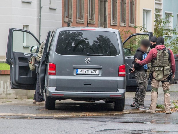  Policiais prendem um suspeito em área residencial em Chemnitz neste sábado (8)  (Foto: Bernd Merz/DPA/AFP)
