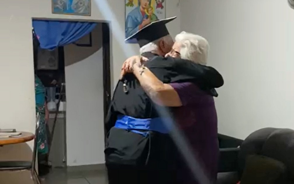 “Mãe, eu formei!”: Idoso viraliza ao ir até mãe, de 97 anos, usando beca e com diploma em MG; veja VÍDEO — Foto: Reprodução