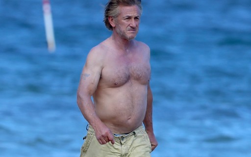 Sem camisa, Sean Penn faz caminhada em praia no Havaí