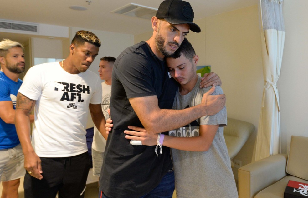 Cauan é abraçado pelo zagueiro Rodolfo antes de deixar hospital  — Foto: Reprodução/Flamengo 
