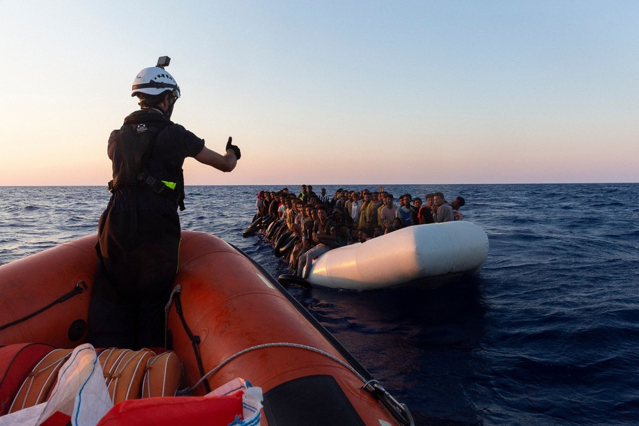 Uma crise sem fim: bote salva-vidas da Sea-Watch se aproxima de barco inflável com 120 migrantes a bordo no Mediterrâneo central