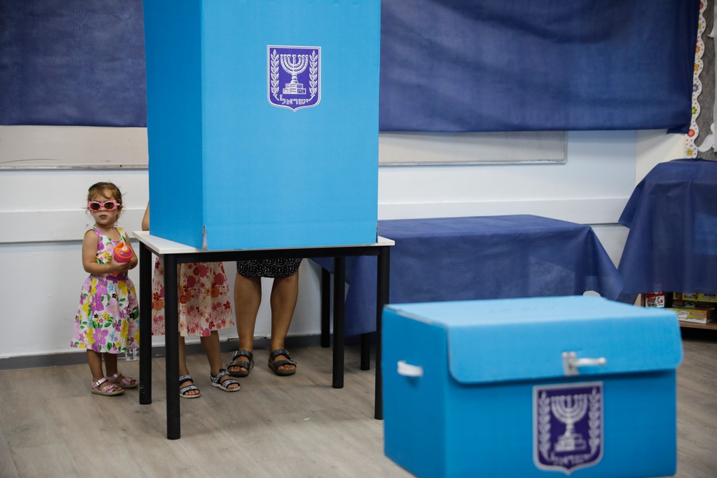 Uma mulher vota com crianças em uma sessão eleitoral de Rosh Haayin, em Israel, em 2019 — Foto: Sebastian Scheiner/AP