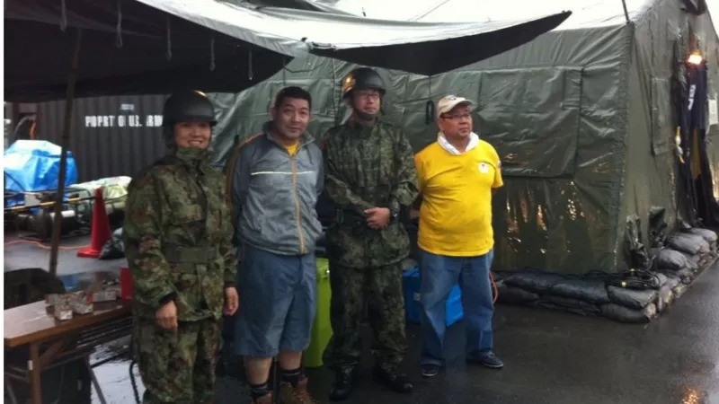 Miguel Kamiunten (de cinza), junto a militares nos abrigos após terremoto de Tohoku em 2011 (Foto: ARQUIVO PESSOAL/BBC)