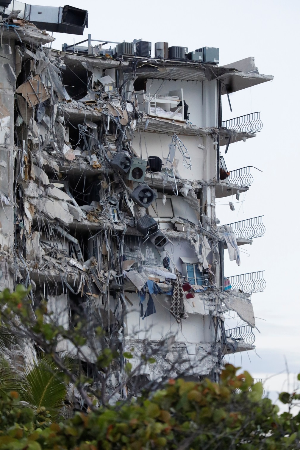 24 de junho - Destroços e pertences são vistos na lateral de um prédio residencial de 12 andares que desabou parcialmente em Miami Beach, na Flórida, EUA. Tragédia deixou dezenas de mortes e desaparecidos nos escombros — Foto: Marco Bello/Reuters