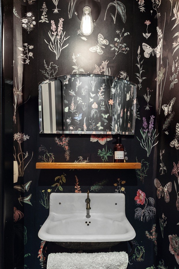 Lavabo. Papel de parede floral da Branco reveste o cômodo, com pia e espelho de antiquário (Foto: Cristiano Bauce / Divulgação)
